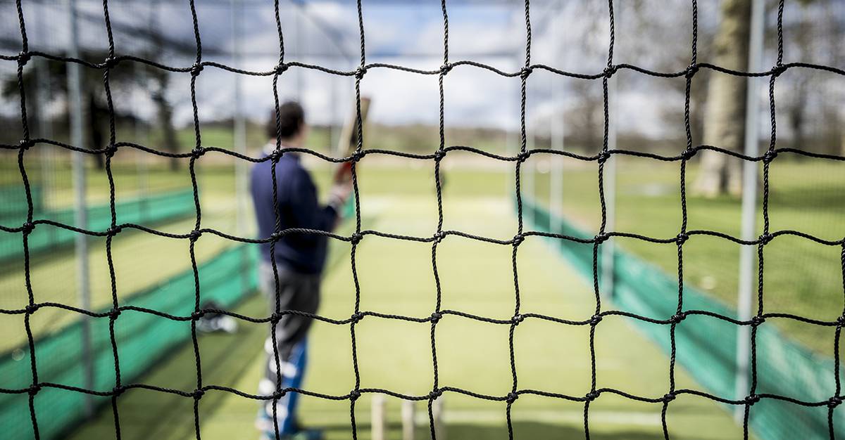 a man is practicing with a cricket net